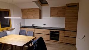 a kitchen with wooden cabinets and a wooden table at Apartment Aghel in Ortisei