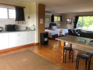 Habitación con 2 camas, cocina y sala de estar. en Bee’s Knees Cottage, en Winterton