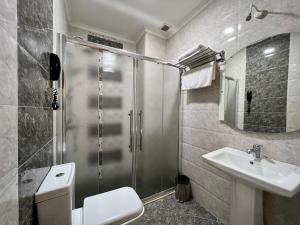 uma casa de banho com um chuveiro, um WC e um lavatório. em Mensen Hotel Baku em Baku