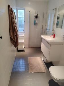 uma casa de banho branca com um lavatório e um WC em Villa Stockholm Täby em Estocolmo
