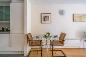 a dining room with a glass table and chairs at Luxury 1 Bed Apartment Close To Excel & o2 in London