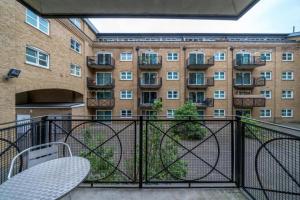 a balcony with two chairs and a building at Luxury 1 Bed Apartment Close To Excel & o2 in London