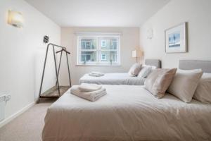 a white room with a bed and a couch at Luxury 1 Bed Apartment Close To Excel & o2 in London
