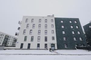 um grande edifício branco com neve em frente em Nowy Złocień Comfort Apartment em Cracóvia
