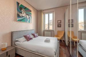 a bedroom with a bed and a chair and windows at Stunning Center Rome Apartment in Rome