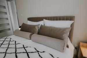 uma cama com algumas almofadas em cima em Nowy Złocień Comfort Apartment em Cracóvia