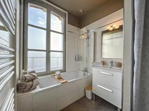a bathroom with a tub and a sink and a window at Le Patio’nnement, Troyes, Centre in Troyes +10 photos
