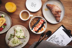 a table with plates of food and a cup of coffee at Boutiquehotel DAS ZEITWERT in Deutschlandsberg