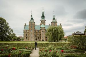 una persona caminando frente a un castillo con flores en Deluxe Flat at Perfect Location en Copenhague