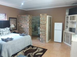 a bedroom with a bed and a brick wall at Aub Guesthouse - Mariental in Mariental
