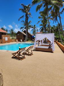 a swimming pool with a tent and benches next to a resort at Cabana Beach Lodge in Cabo Conguiane