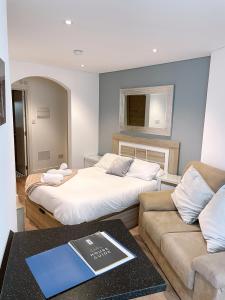 a bedroom with two beds and a book on a table at Delightful City Centre Studio Clarendon Apartment - Grand Central House in Gibraltar