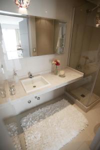 a bathroom with a sink and a mirror at Byblos Palermo Soho in Buenos Aires +77 photos