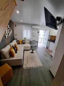 een woonkamer met een bank en een flatscreen-tv bij Camarote Beach in Nazaré