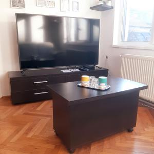 クルジュ・ナポカにあるAPARTMENT POPS 2の大型ブラックエンターテイメントセンター(大画面薄型テレビ付)