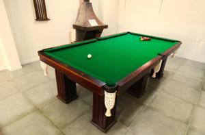a green pool table with a cue ball on it at Pousada Serra Branca in São Thomé das Letras