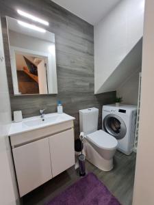 een badkamer met een toilet en een wasmachine bij Camarote Beach in Nazaré