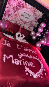 a red blanket with a happy birthday sign and balloons at RR Jacuzzi in Saint-Laurent-des-Arbres