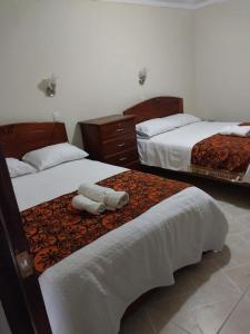 um quarto de hotel com duas camas com lençóis brancos em Monte Gocta em Valera