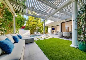 an outdoor patio with a couch and a lawn at Stylish & Modern 5 Bedroom Villa in Los Angeles