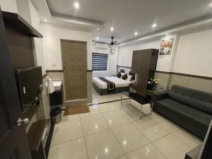 a living room with a bed and a couch at ABUDHABI RESIDENCY in Palakkad