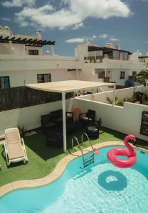 a pool with a swan in the middle of a house at La Fresa Hostel in Corralejo