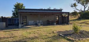 ein kleines Haus auf einem Feld mit einem Zaun in der Unterkunft Bundu Camp in Heilbron