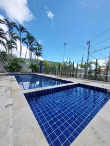 uma piscina com piso de azulejo azul e palmeiras em Quarto em Florianópolis em Florianópolis