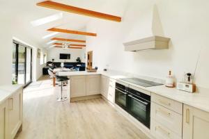 a kitchen with white cabinets and a stove top oven at Rare Luxury Holiday Home with Hot-Tub in Belton
