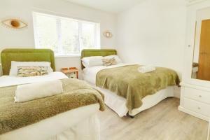 a bedroom with two beds and a window at Rare Luxury Holiday Home with Hot-Tub in Belton