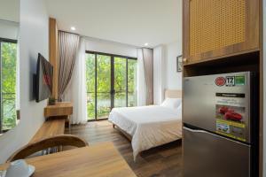 a small room with a bed and a refrigerator at Studio-Vincent Apartment HaNoi in Hanoi