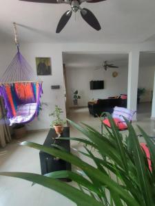 uma sala de estar com uma ventoinha de tecto e um sofá em CASA CORAZA em Cancún