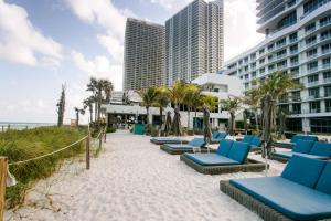 a row of blue lounge chairs on the beach at Sian Oceanfront Condos in Hollywood