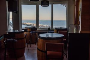 a bar with a view of the ocean through the windows at Palm Hotel Le Kram in Le Kram