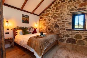 The Ruin - Lochside Cottage dog friendly في اولابول: غرفة نوم مغطاة بالحجر مع سرير في غرفة