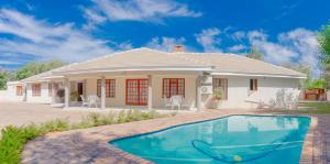 uma casa com uma piscina em frente em Green Lagoon Guest House Tawana em Gaborone