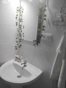 La salle de bains blanche est pourvue d'un lavabo et d'un miroir. dans l'établissement FLAMING CB, à Cullera