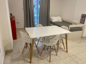 einen weißen Tisch und Stühle in einem Zimmer mit einem Bett in der Unterkunft Dpto Pleno Centro con Asador y Cochera in Santa Fe