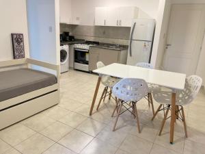 a kitchen with a table and chairs and a refrigerator at Dpto Pleno Centro con Asador y Cochera in Santa Fe