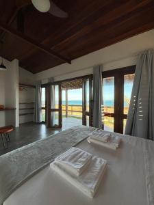 1 dormitorio con 1 cama con 2 toallas en Pousada Villa Sagi, en Baía Formosa