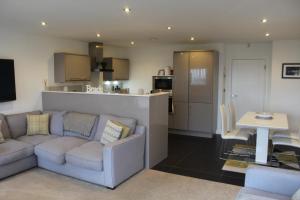 a living room with a couch and a kitchen at 1 Island View in Portrush