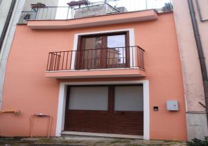 - un bâtiment orange avec un balcon et une porte dans l'établissement Casa nel Centro di Avellino, à Avellino
