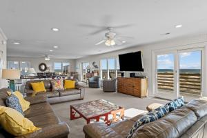 a living room with couches and a flat screen tv at 7019 - Sara's Sea Breeze by Resort Realty in Rodanthe