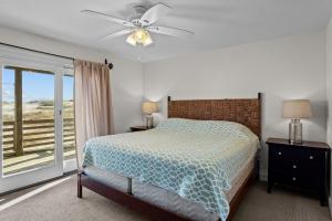 a bedroom with a bed and a ceiling fan at 7019 - Sara's Sea Breeze by Resort Realty in Rodanthe
