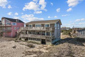 a house sitting on top of a sandy beach at 7019 - Sara's Sea Breeze by Resort Realty in Rodanthe