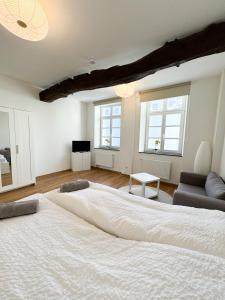 uma grande cama branca num quarto com duas janelas em Praktisch & modern - voll ausgestattetes Apartment em Stolberg