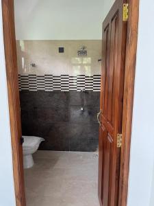 an open door to a bathroom with a toilet at Samarathunga Guest House in Katunayake