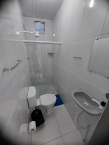 een witte badkamer met een toilet en een wastafel bij Suítes good trip Itacare sem estacionamento in Itacaré