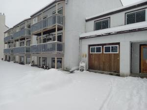 a snow covered parking lot in front of a building at Ski to your back door! Shared condo with ski professional and cat. in Warren