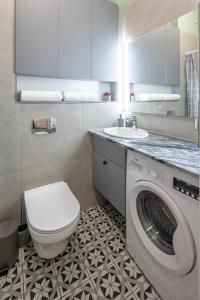 a bathroom with a washing machine and a sink at Apartments on Krakowska street in Lviv
